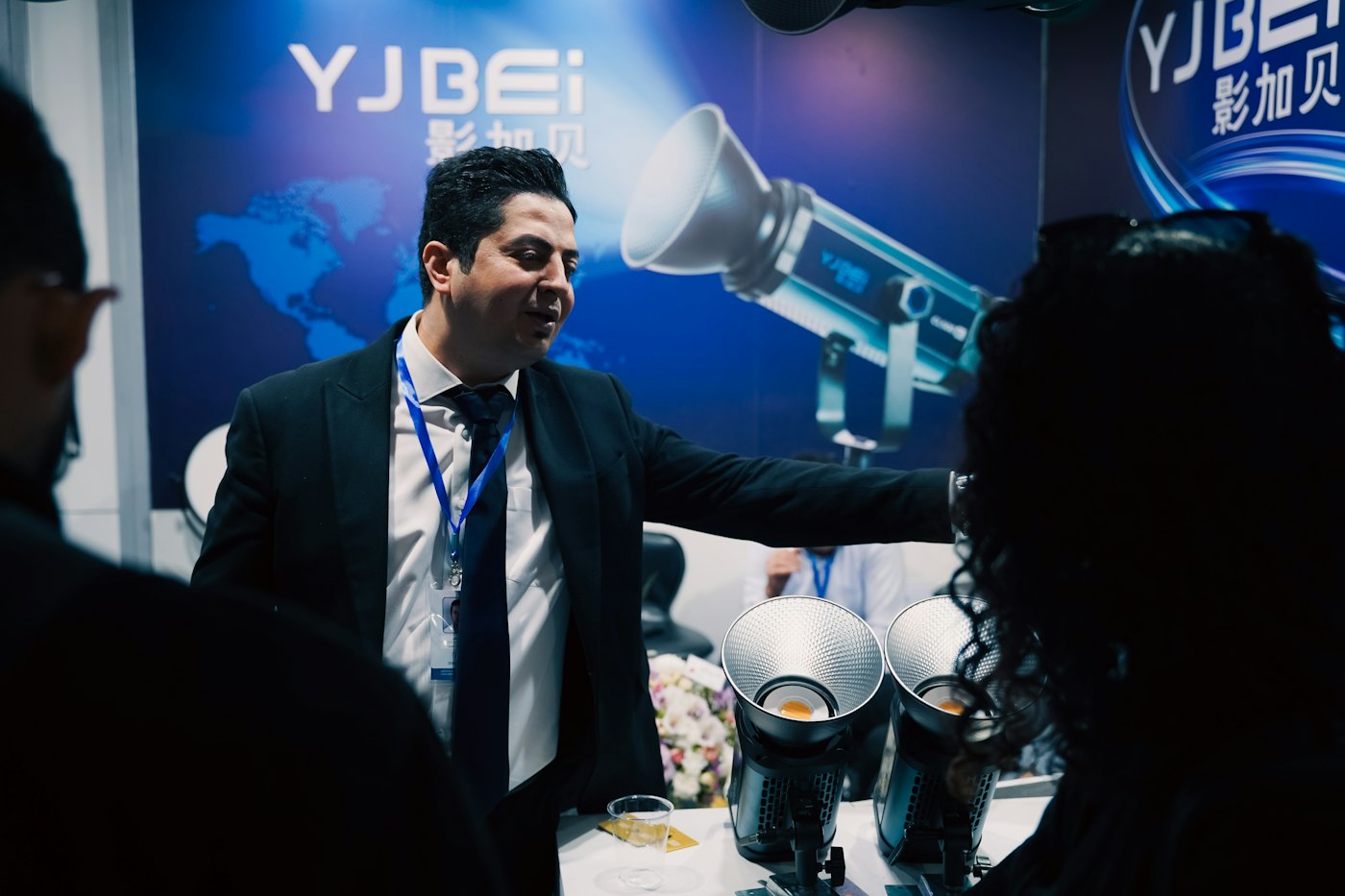An exhibitor demonstrating equipment to visitors on a stand
