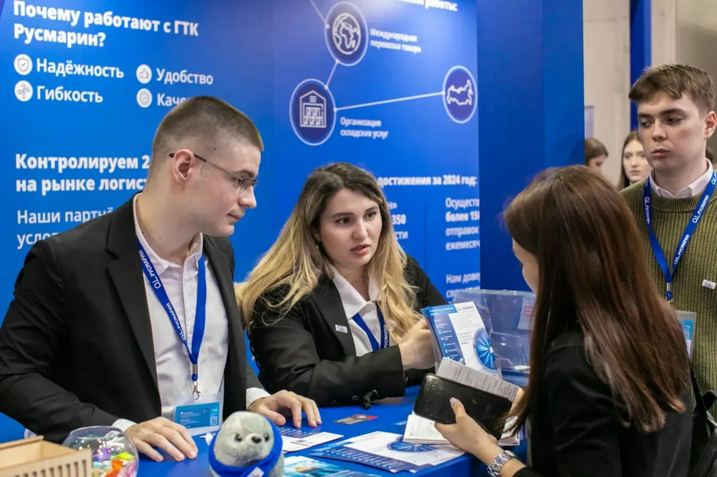 Visitors talking to exhibitors at a trade show stand